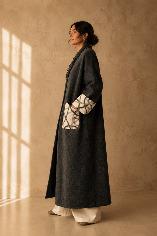 Nuno Milano dark charcoal felted Merino wool robe coat, side view, showing contrasting cream and green abstract-print pocket and cuff detail