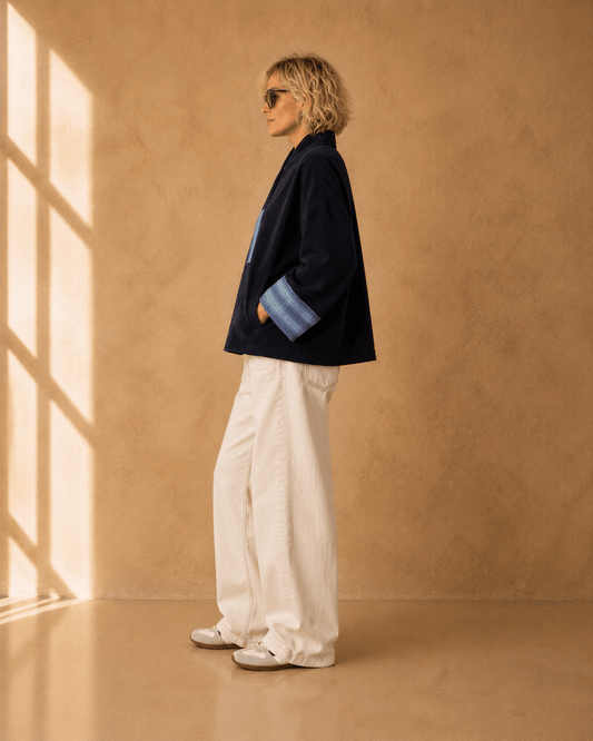Nuno Milano Aki navy felted Merino wool jacket, side view, showing wide contrasting light blue turned-back cuffs and relaxed cropped silhouette