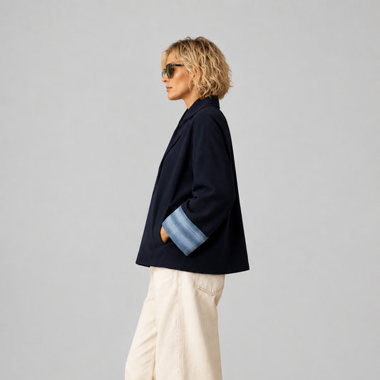 Veste Nuno Milano Aki en laine mérinos feutrée bleu marine, vue de côté, avec larges poignets retroussés contrastés bleu clair et silhouette courte décontractée