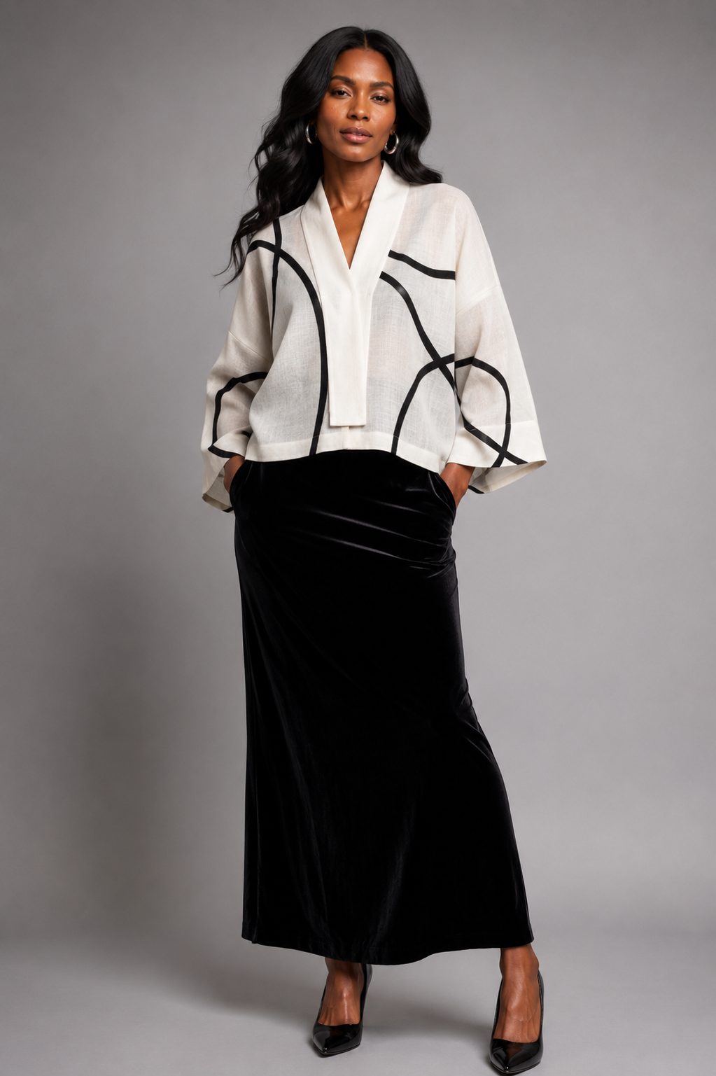 Model wearing the Nuno Milano Lightweight White Graffiti Kimono Jacket, featuring a relaxed kimono silhouette in ivory with bold black geometric Graffiti lines, styled over a black velvet maxi skirt