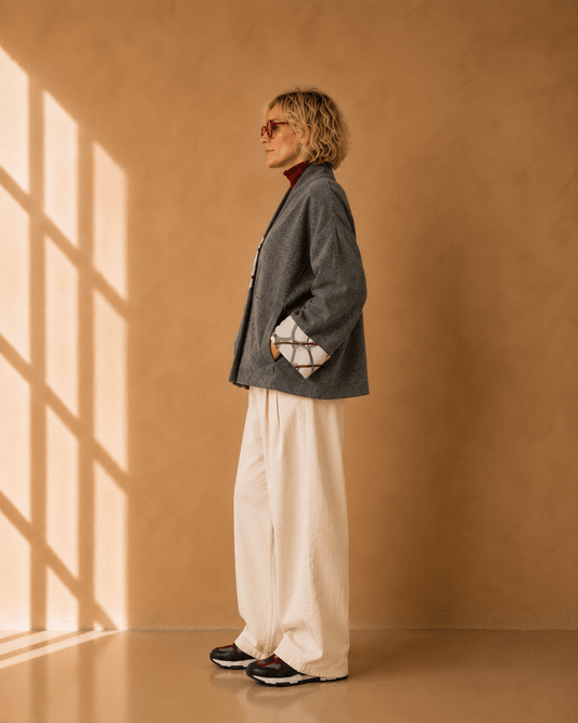 Nuno Milano Aki grey felted Merino wool jacket, side view, showing contrasting cream and burgundy abstract-print turned-back cuffs and relaxed cropped silhouette