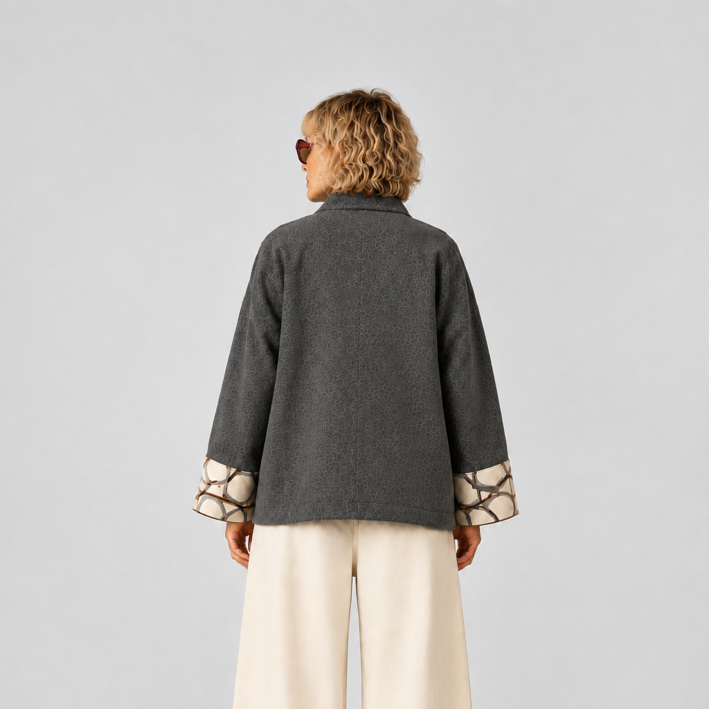 Nuno Milano Aki grey felted Merino wool jacket, back view, cropped length with centre back seam detail and contrasting cream and burgundy abstract-print cuffs