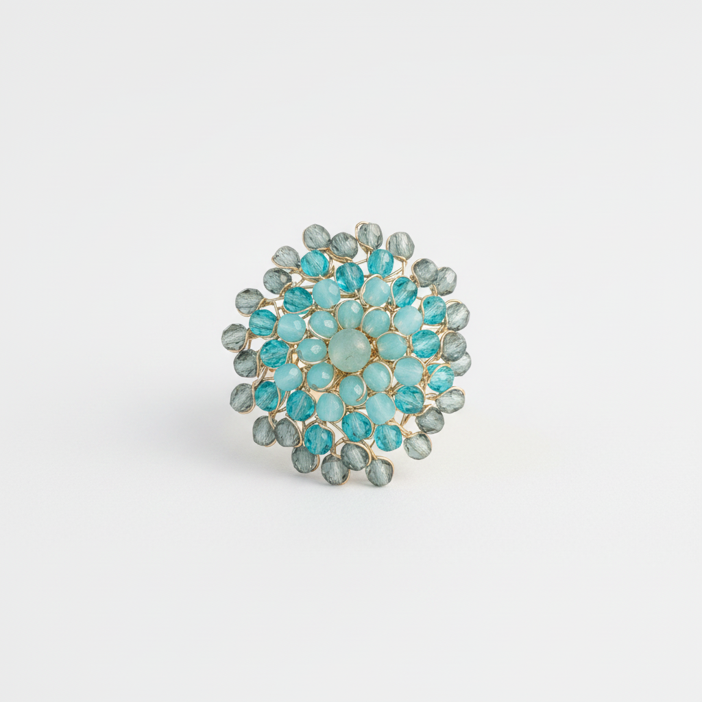 An acqua and grey swarovsky crystal Mandala design ring on a white background.