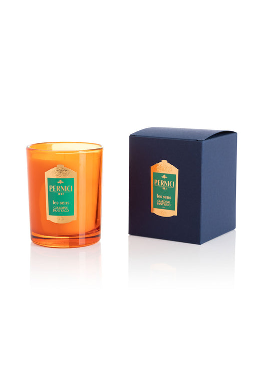 Cereria Pernici Les Sens Giardino Pantesco 70g scented candle in a deep amber glass tumbler with green and gold Pernici label, shown alongside its navy blue gift box with gold foil label, product shot on white background