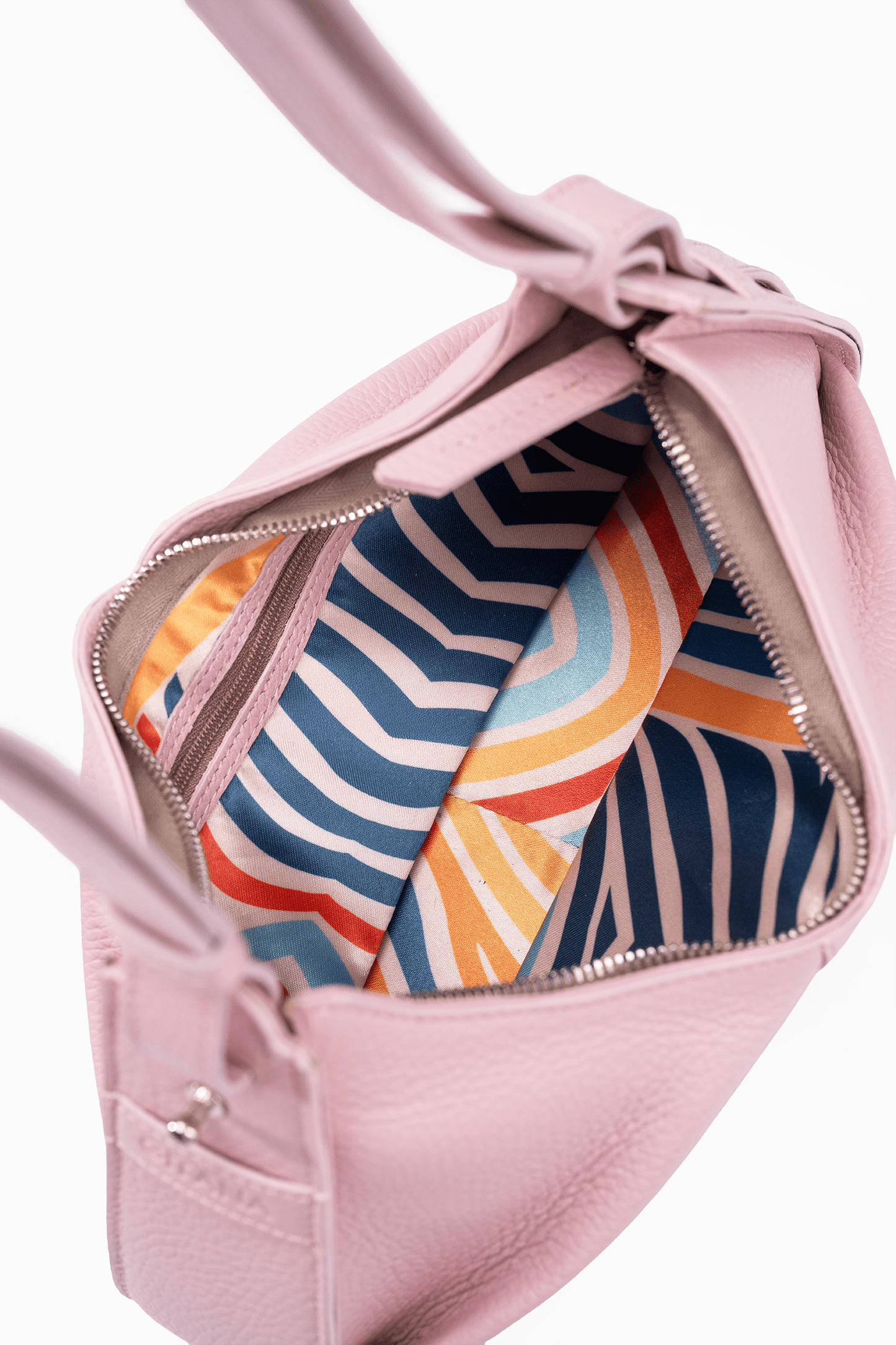 The inside of a luxury petal pink leather shoulder bag. The photo focuses on the colourful inside lining.