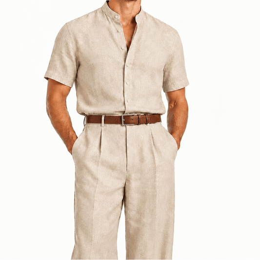 Un homme en chemise en lin beige clair à manches courtes et pantalon en lin assorti, avec une ceinture en cuir marron, sur fond blanc uni.