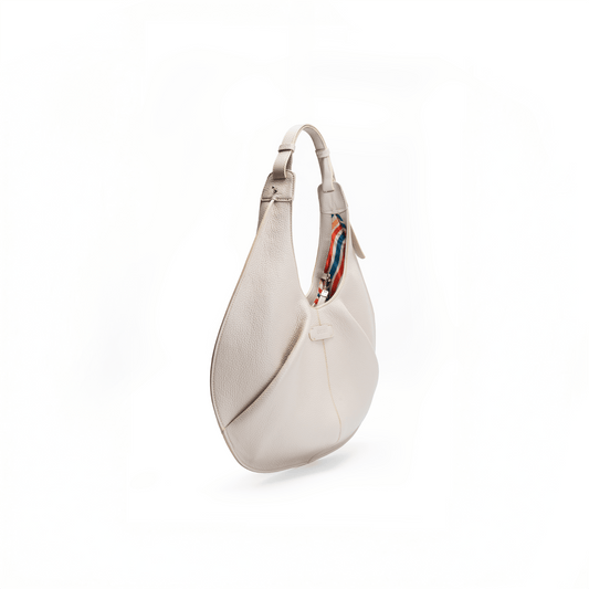 Side view of a large beige luxury Italian pebble calf tote handbag on a white background.