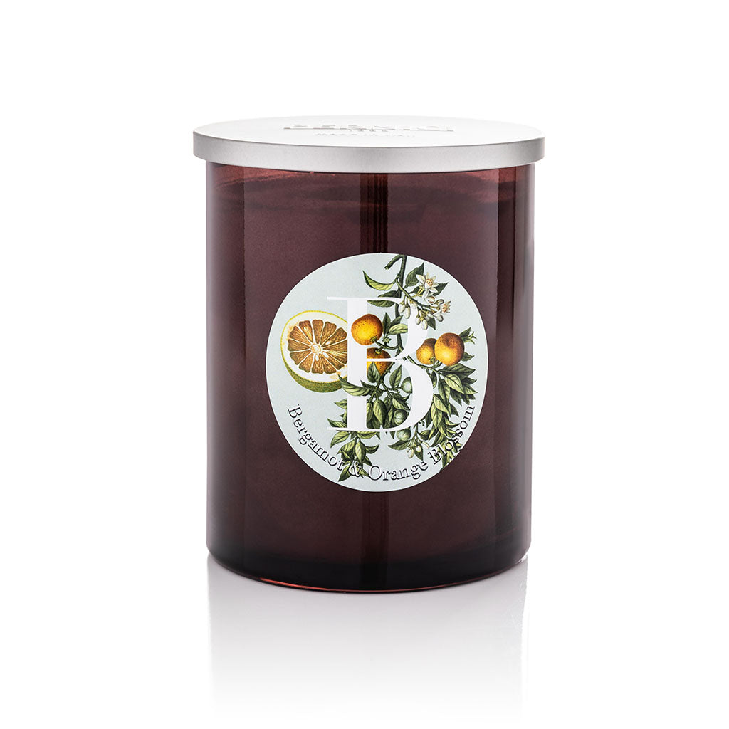 Cereria Pernici Elementi Bergamot & Orange Blossom scented candle in a dark amber glass jar with silver lid, featuring a botanical illustrated label with citrus fruits and orange blossom, product shot on white background