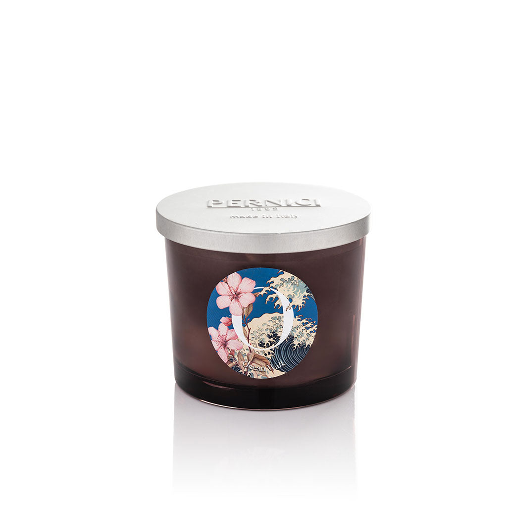 Cereria Pernici Elementi Ocean Walk 200g scented candle in a dark amber glass jar with silver Pernici lid and circular label featuring cherry blossom and Japanese wave illustration on a blue background, product shot on white background