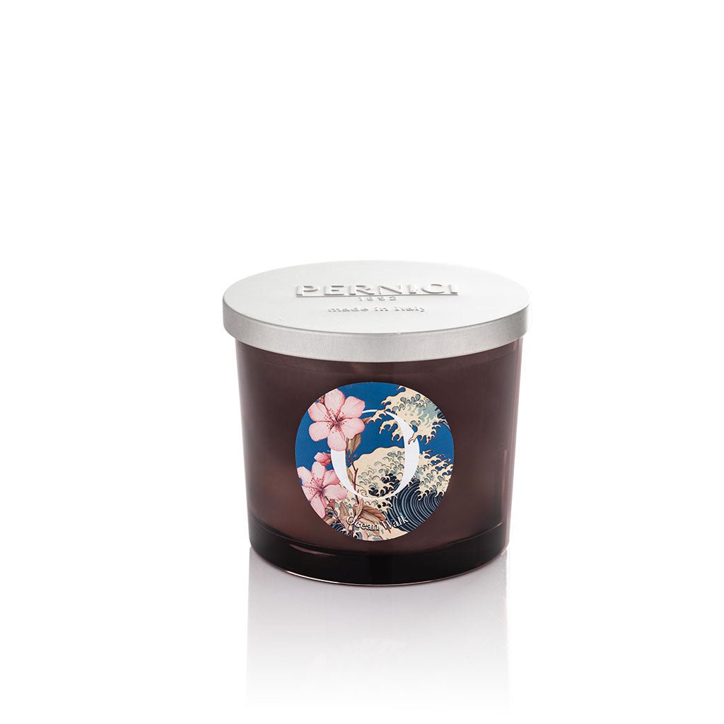 Cereria Pernici Elementi Ocean Walk 200g scented candle in a dark amber glass jar with silver Pernici lid and circular label featuring cherry blossom and Japanese wave illustration on a blue background, product shot on white background