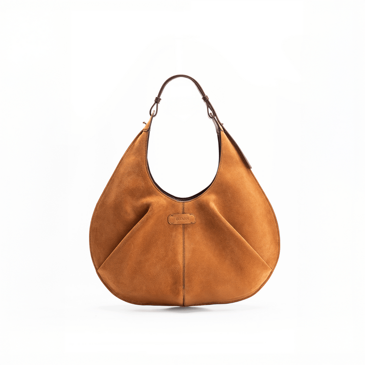 Front view of a large red luxury suede tote handbag on a white background. holding a red suede Gitana tote red suede leather bag, wearing blue cotton jeans, a light blue blouse, and a patterned headscarf.