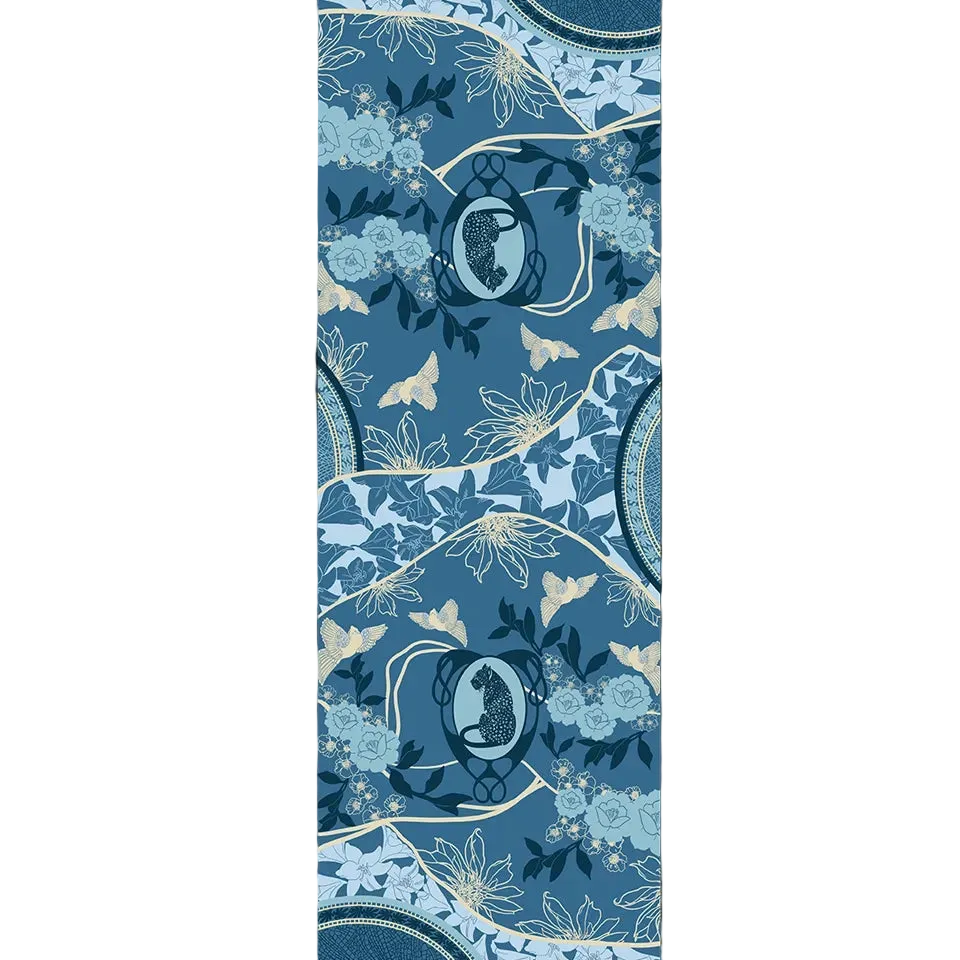 Leopard Azure cashmere scarf print shown flat, with two spotted leopards in pale blue Art Nouveau oval frames, powder-blue roses, lilies, cream star-shaped flowers and golden-cream birds on rolling denim-blue hills outlined in cream, with mosaic medallions at the edges.