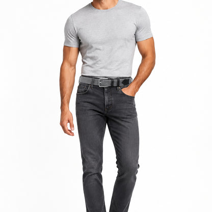 A man wearing dark grey jeans with a grey braided woven belt with a silver metal buckle and black leather accents, a light grey t-shirt on a plain white background.