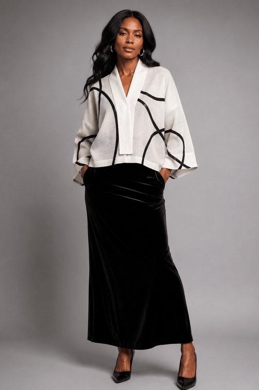 Model wearing the Nuno Milano Lightweight White Graffiti Kimono Jacket, featuring a relaxed kimono silhouette in ivory with bold black geometric Graffiti lines, styled over a black velvet maxi skirt