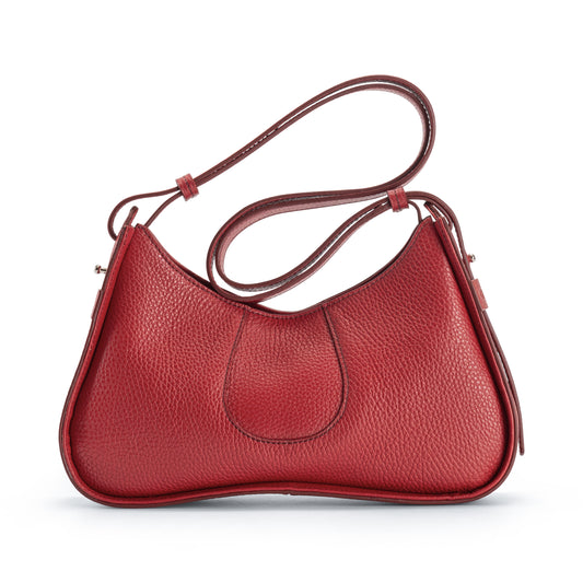 A red pebbled leather shoulder bag with a curved, crescent-shaped silhouette, a single shoulder strap, and a central stitched detail, shown on a plain white background.