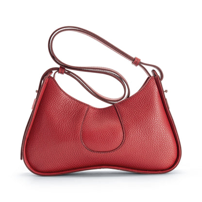 A red pebbled leather shoulder bag with a curved, crescent-like silhouette and a matching adjustable shoulder strap, shown from the back on a clean white background.
