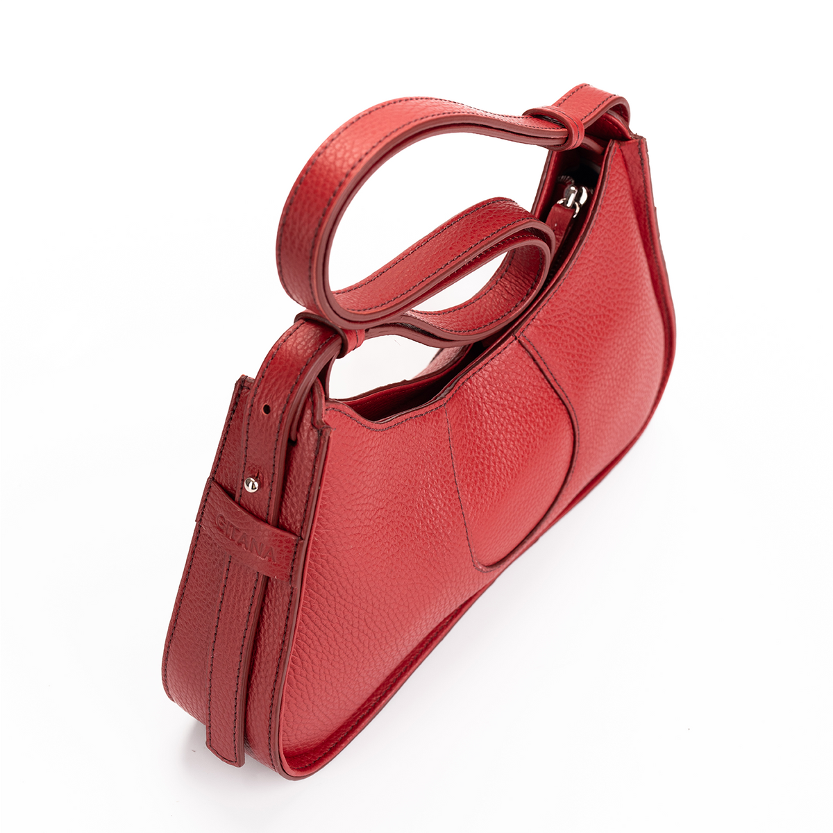 A red pebbled leather handbag with a double top handle and a side strap detail, photographed on a clean white background.