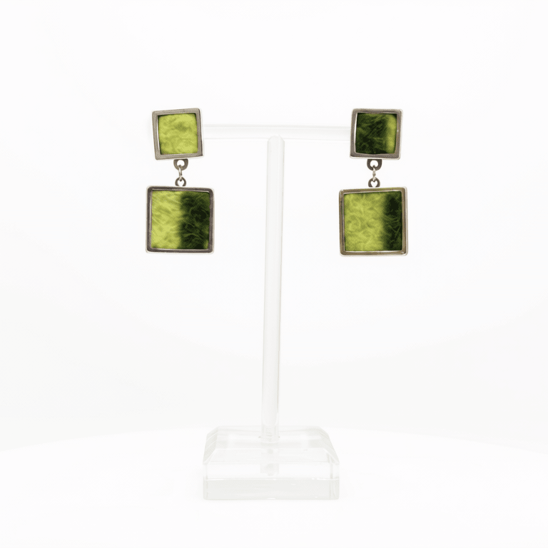 A pair of square drop earrings displayed on a clear acrylic T-stand against a white background. Each earring features a top silver-tone square with a lime & dark green marbled pattern, connected by a small silver chain to a larger bottom square of the same design.