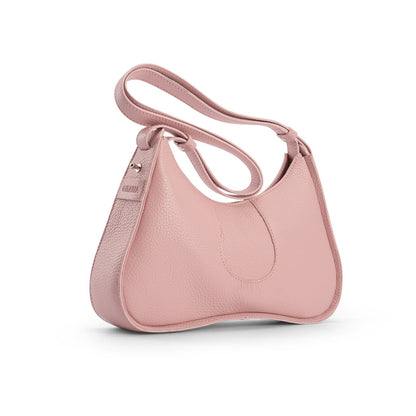 Side view of a blush pink pebbled leather shoulder bag with a curved designer silhouette and adjustable strap on a white background.