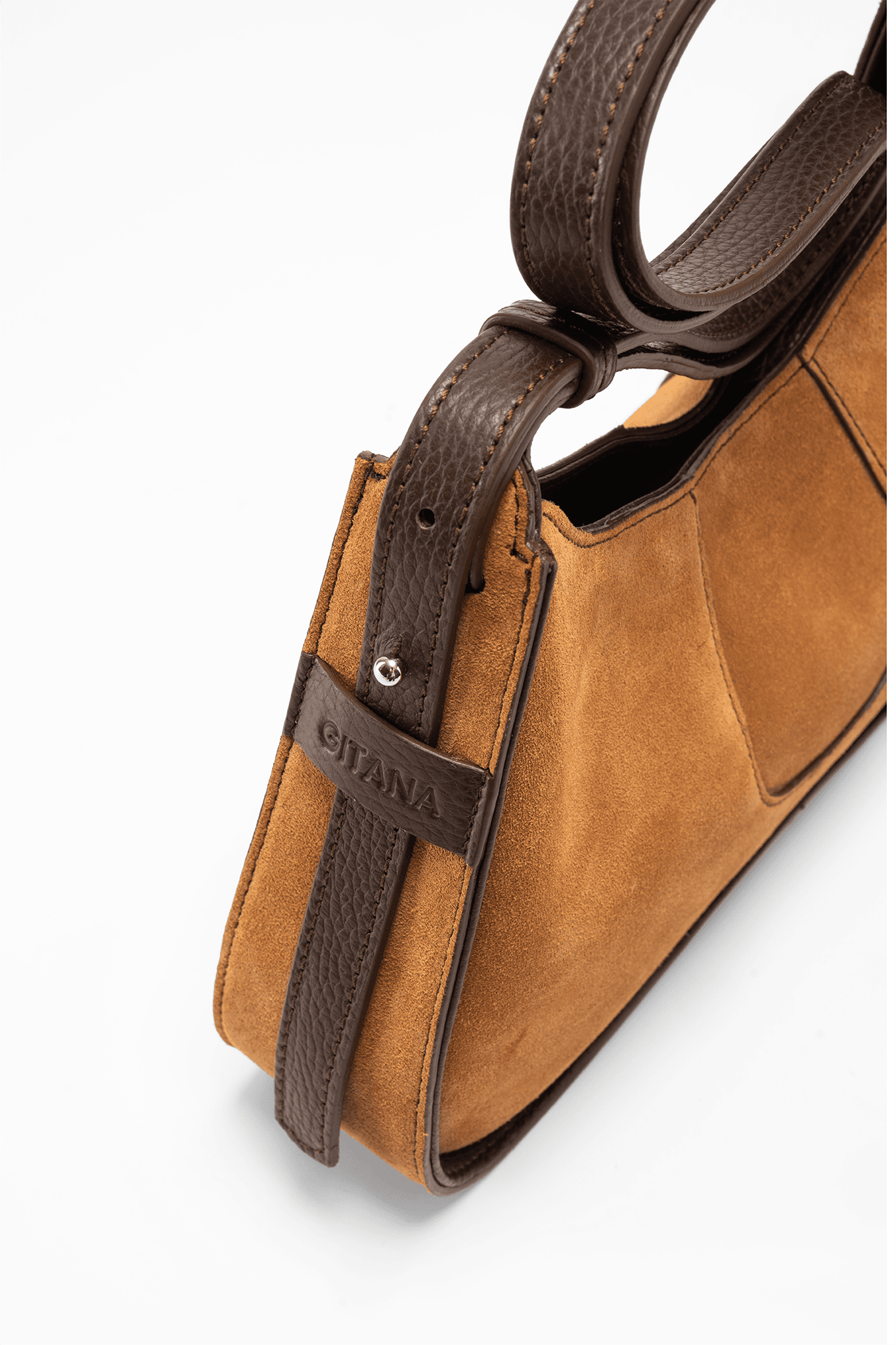 A Close-Up Side View of Aria Shoulder Bag in Caramel Italian Suede Leather with Brown Pebbled Leather Trim - focusing on "Gitana's" Brand Name.