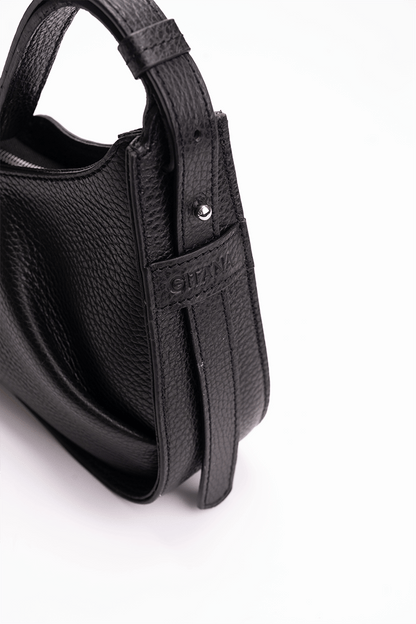 Close-up of the gusset of a luxury black leather shoulder bag with the Gitana branding 