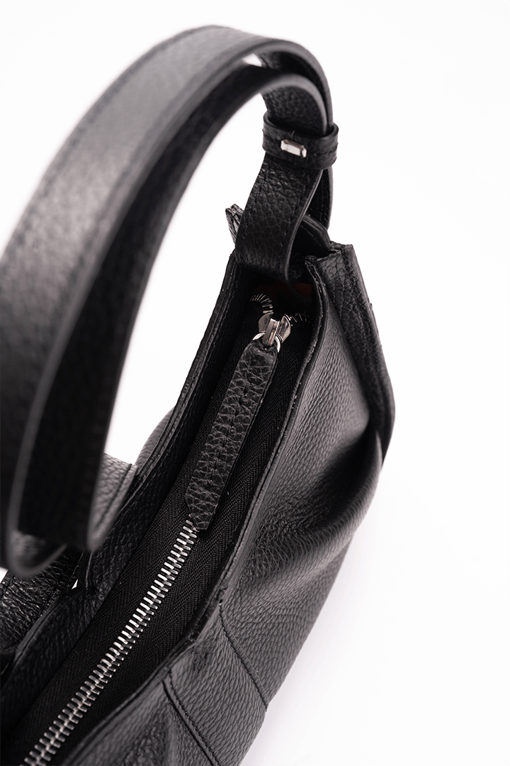 Close-up of a black leather bag with the zipper detail