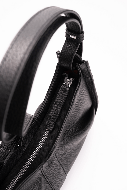 Close-up of a black leather bag with the zipper detail