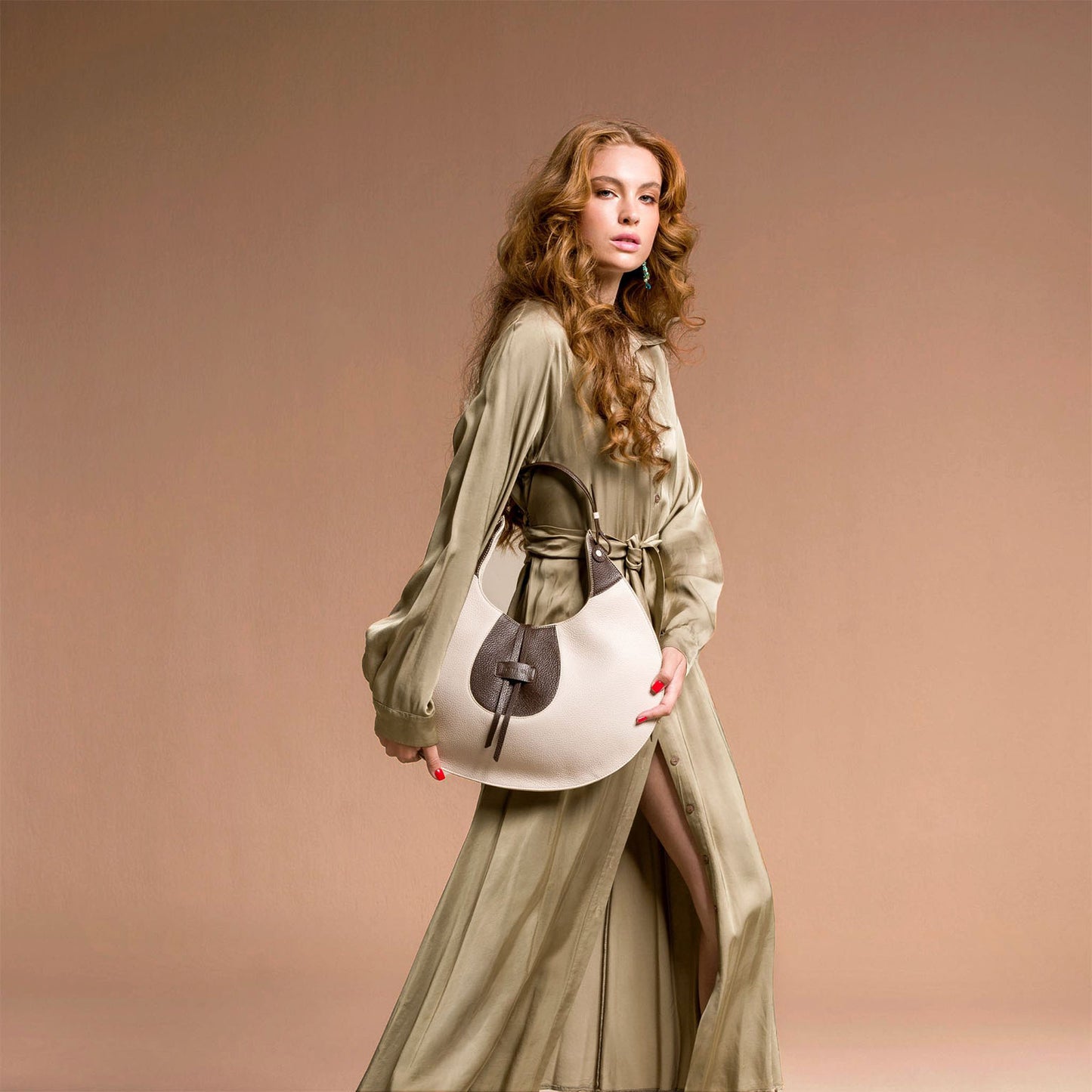 Woman holding a handbag against a beige background