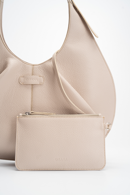 A beige pebble calf leather tote handbag and matching pouch on a white background.