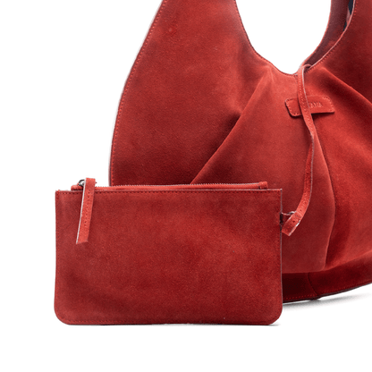 Red suede handbag and matching pouch on a white background.