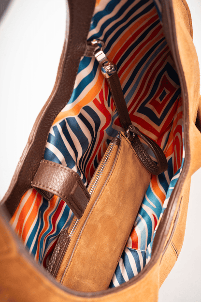 Tan suede leather handbag with colourful interior pattern lining and detachable pouch.