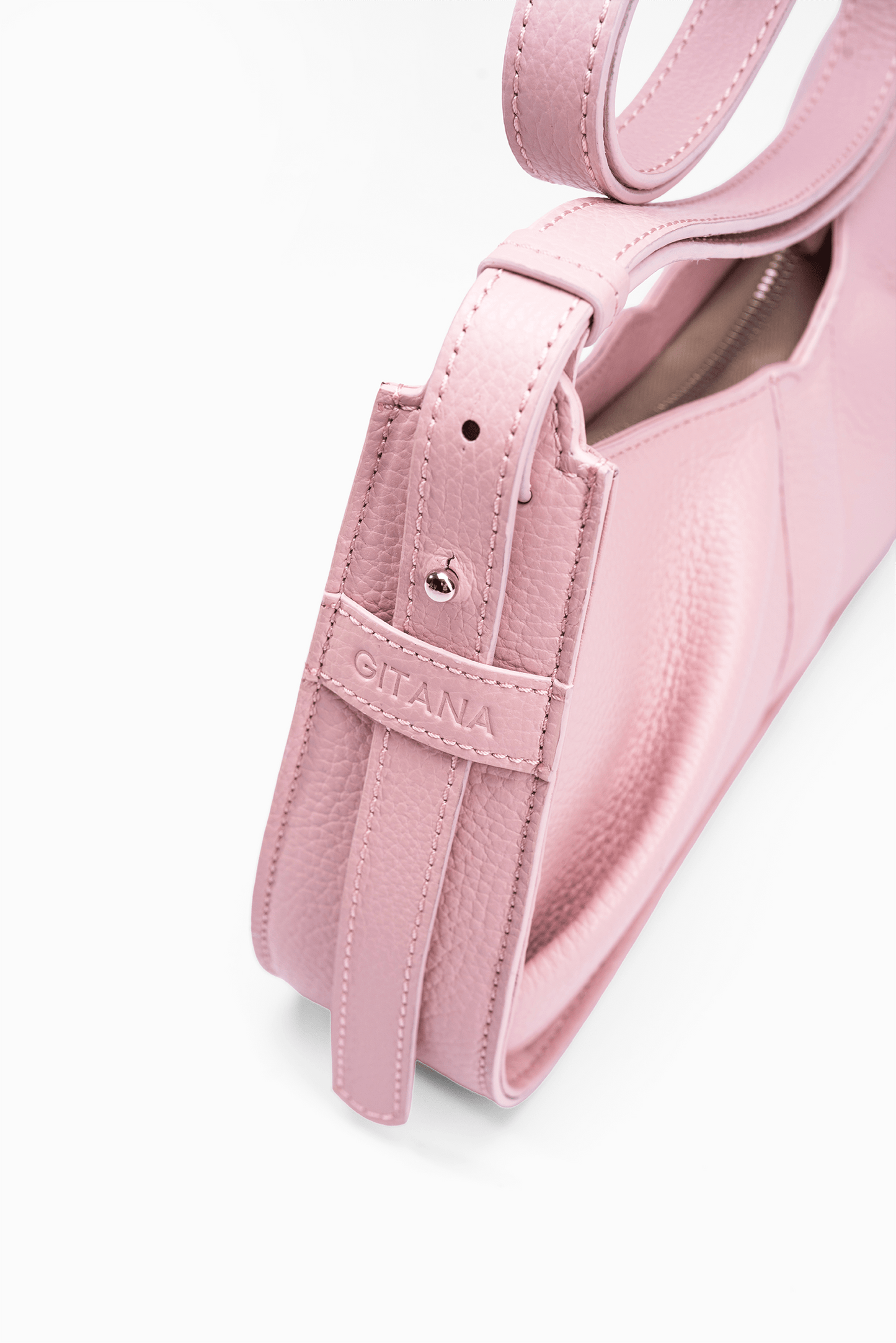 Close-up detail of the Gitana Shoulder Bag Isla in Camelia Italian pebble calf leather, featuring the side gusset, adjustable shoulder strap, textured leather finish, and embossed Gitana logo detail.
