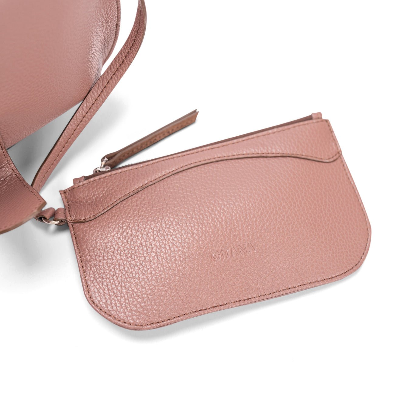 Close-up of a light brown leather designer pouch attached to a luxury handbag by a strap, showcasing the visible brand name.