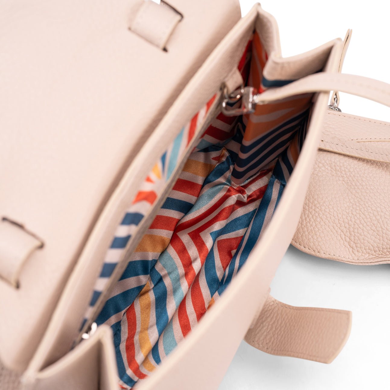 Internal view of a medium-sized beige calf leather luxury women’s handbag showing its colourful patterned lining.