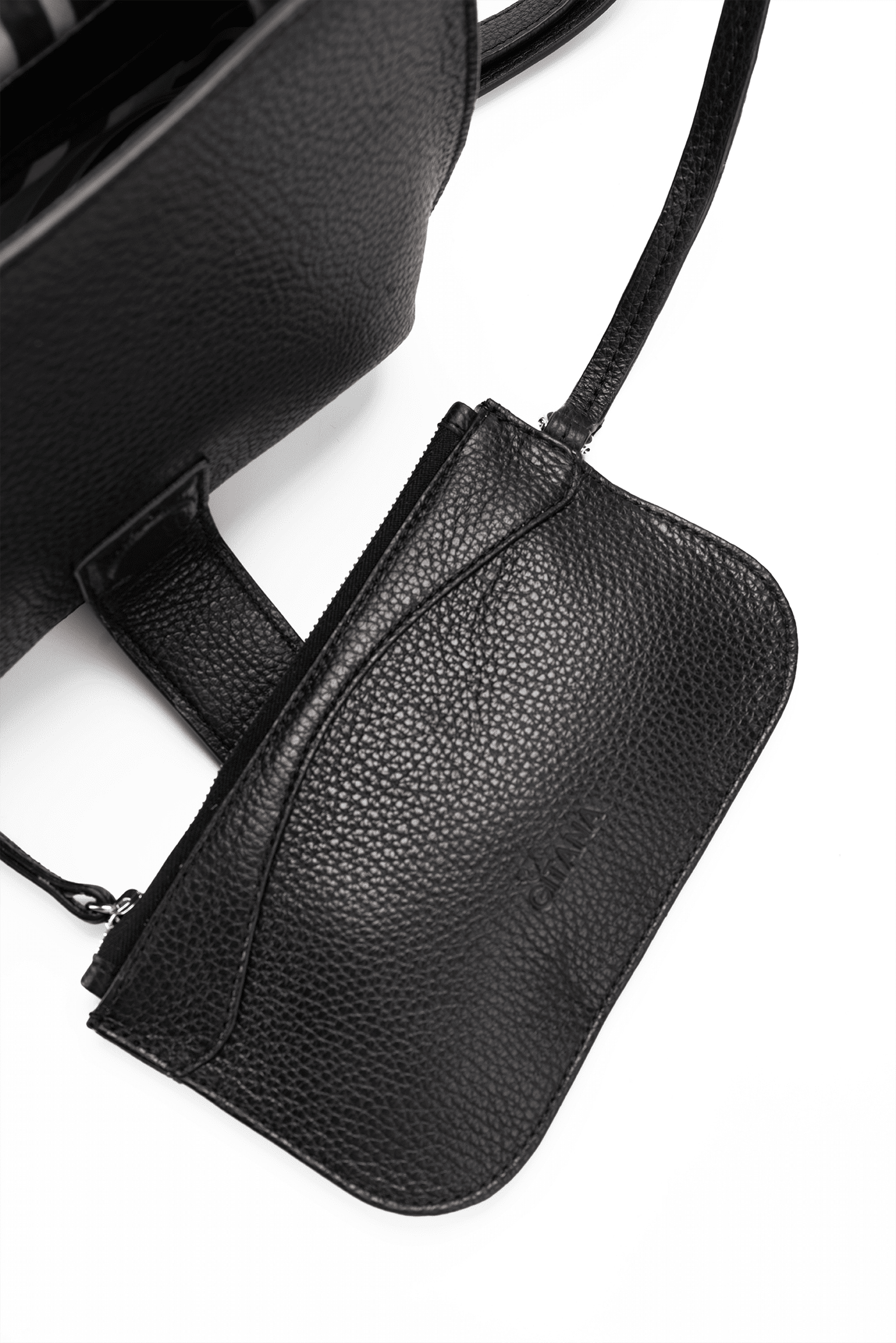 Close-up of a black leather designer pouch attached to a luxury handbag by a strap, showcasing the visible brand name.