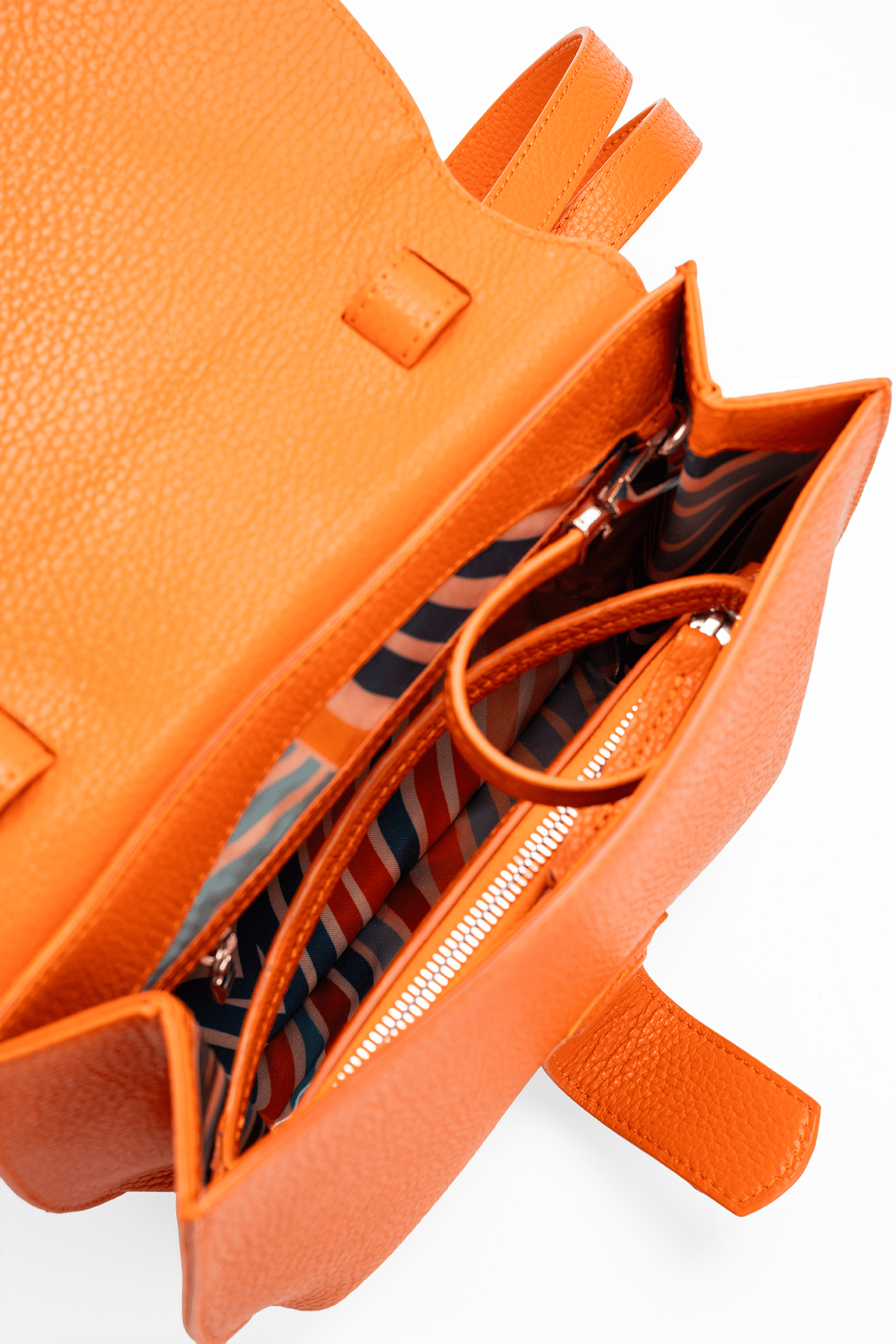 The interior view of Yara Crossbody Italian pebble calf leather bag.  The image focuses on the colourful geometric lining and detachable pouch.