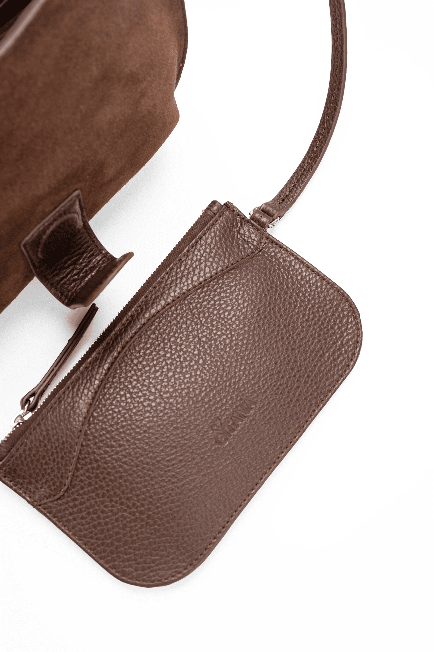 Close-up of a chocolate suede designer pouch attached to a luxury handbag by a strap, showcasing the visible brand name, on a white background.