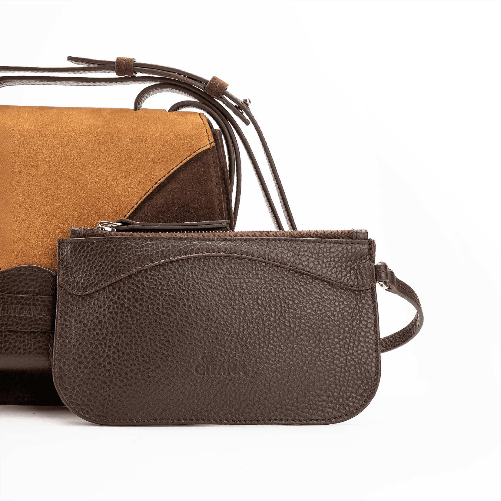 A front view of a luxury crossbody bag in chocolate and caramel suede and matching pouch on attaching strap.