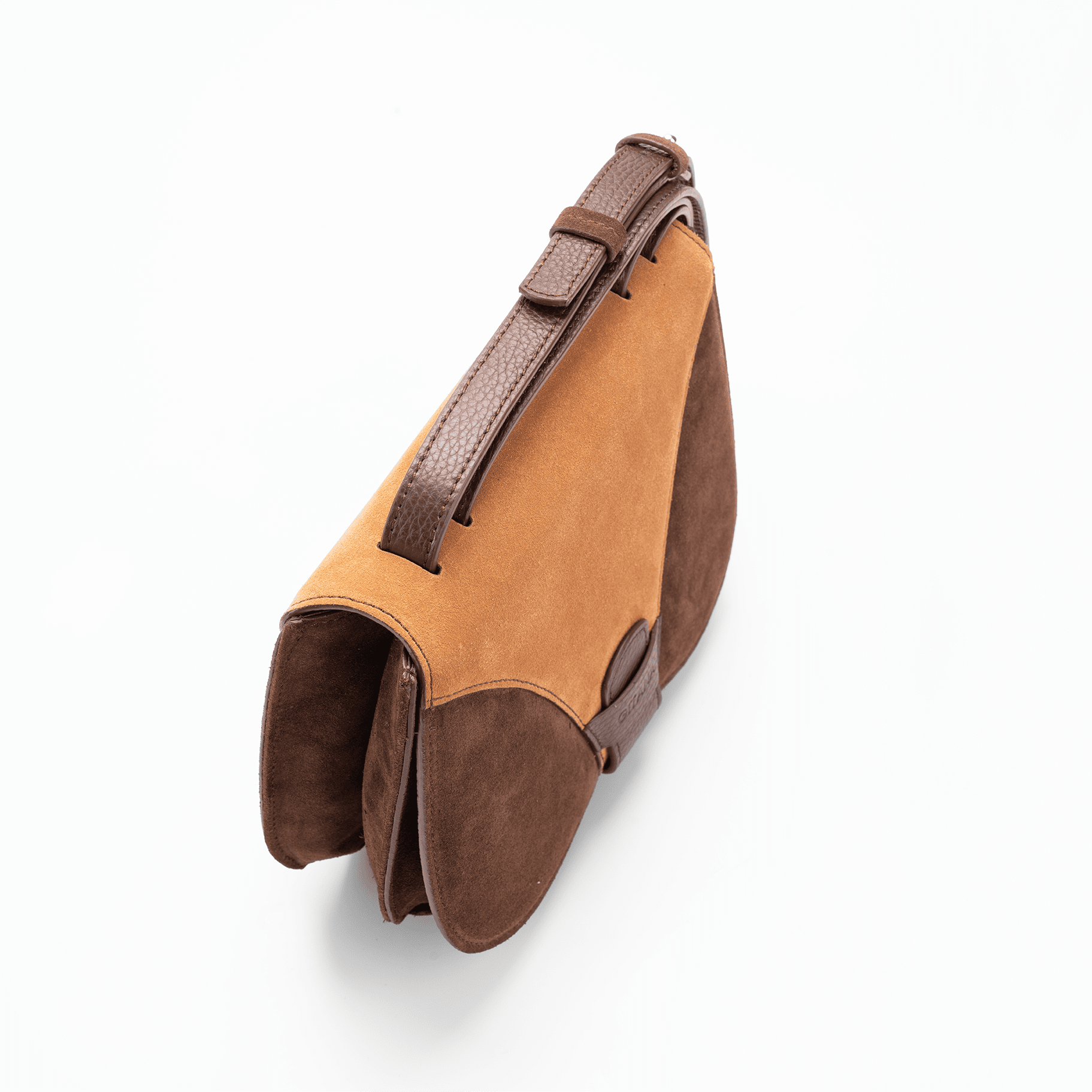 Top view of a medium-sized chocolate and caramel Italian suede leather luxury women’s handbag focusing on the adjustable shoulder strap.