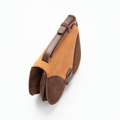 Top view of a medium-sized chocolate and caramel Italian suede leather luxury women’s handbag focusing on the adjustable shoulder strap.