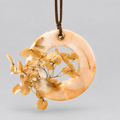 A Golden Peach  scented cupboard wax tablet with a leather string on a white background