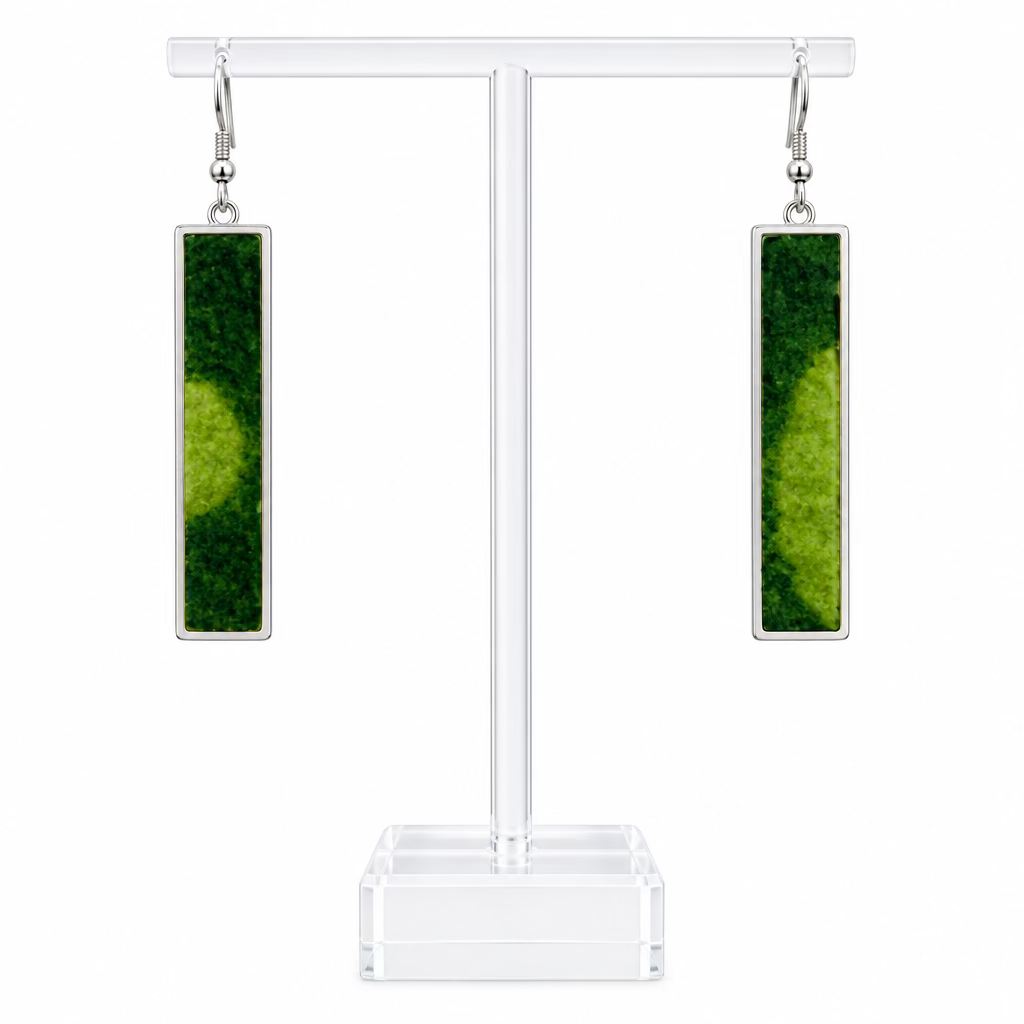 A pair of slim long rectangular pendant earrings on a perspex stand against a white background.  The earrings have a lime and dark green wool centre.