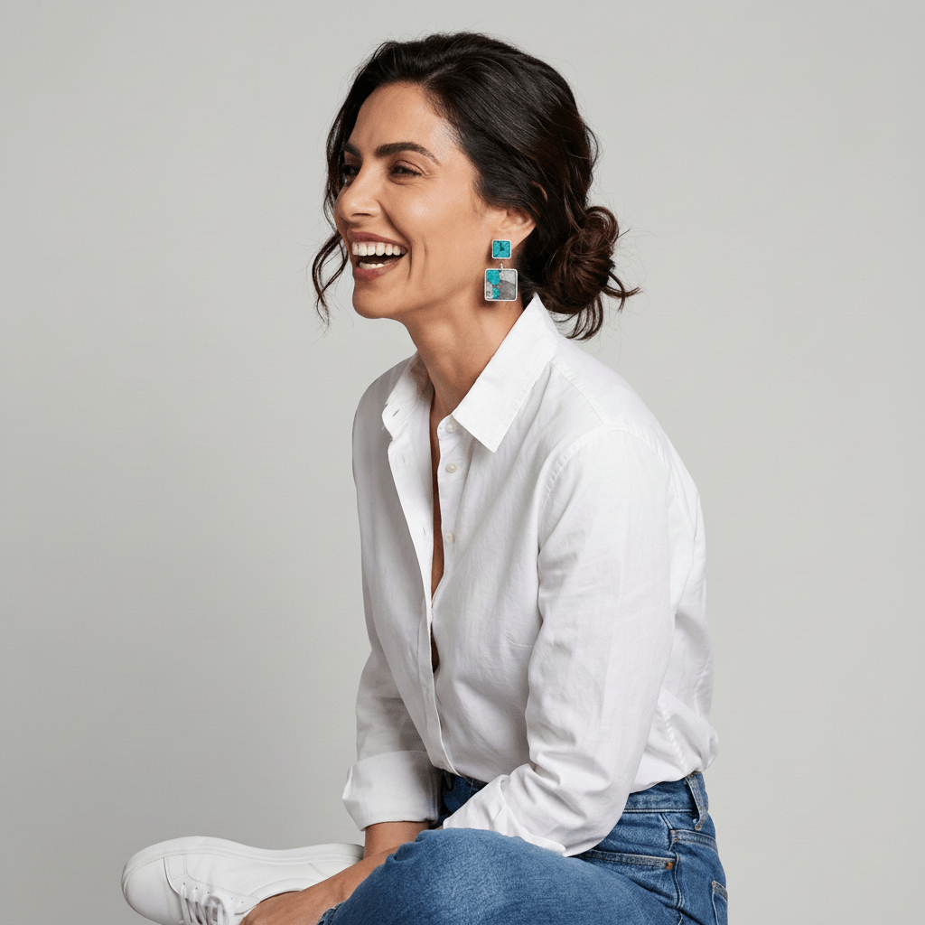 Model wearing Costa double pendant earrings in turquoise and grey marbled Nuno Felt, styled with a white linen shirt and jeans