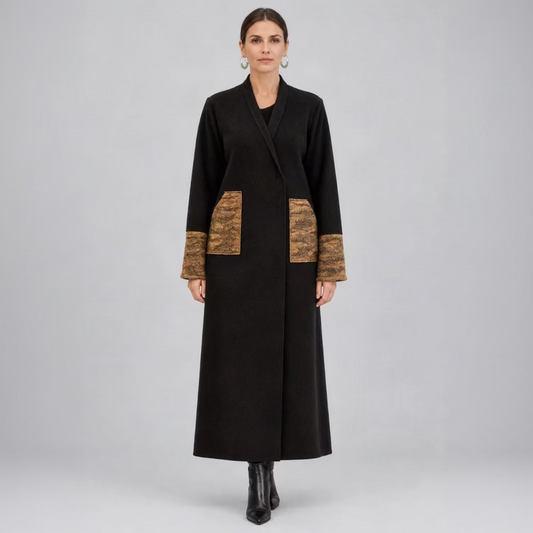 A woman wearing a dark brown wool coat with marbled caramel pocket and cuff details