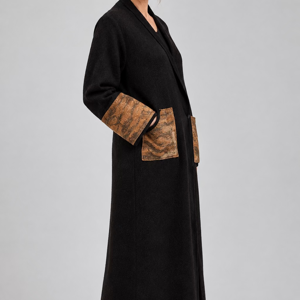 The side view woman wearing a long dark brown kimono robe coat in merino wool  with large brown textured patch pockets and cuffs made from Nuno Felting.