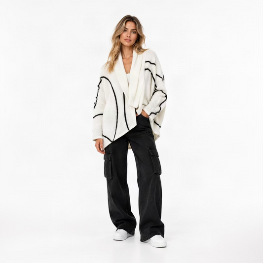 A white merino wool kimono cardigan in Nuno Felt with geometric black lines worn by a blonde lady against a white background.