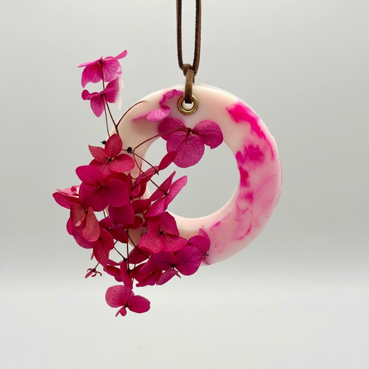 A Rose Bloom  scented cupboard wax tablet with a leather string on a white background
