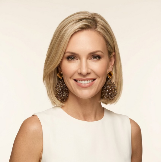 A blonde woman smiling wearing a chic pair of clover leaf bronze teardrop earrings made from bronze crystals.