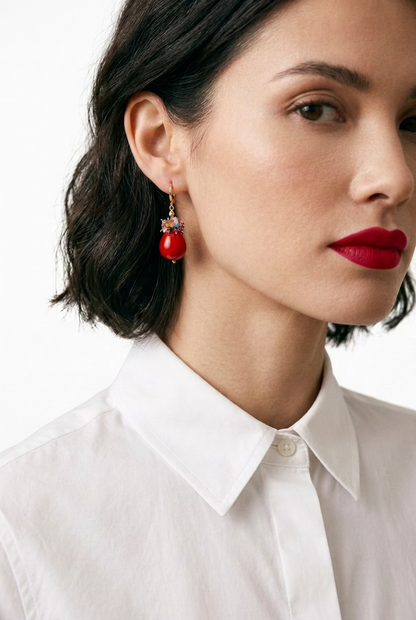A young woman wearing a crisp white shirt paired ith a pair of red lacquered Maiorca pearl earrings with clusterd couloured tourmalines on the top.