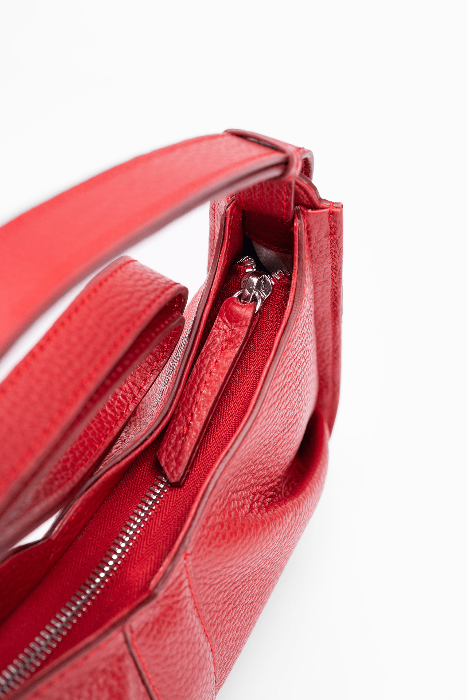 Close-up view of the zip detail of a luxury Italian pebble leather shoulder bag